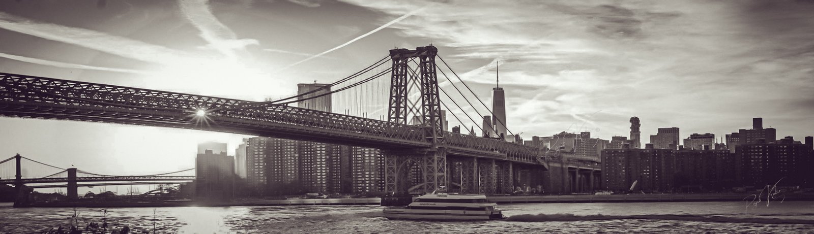Williamsburg Bridge at sunset with New York City skyline, captured by Rajib Kabir.