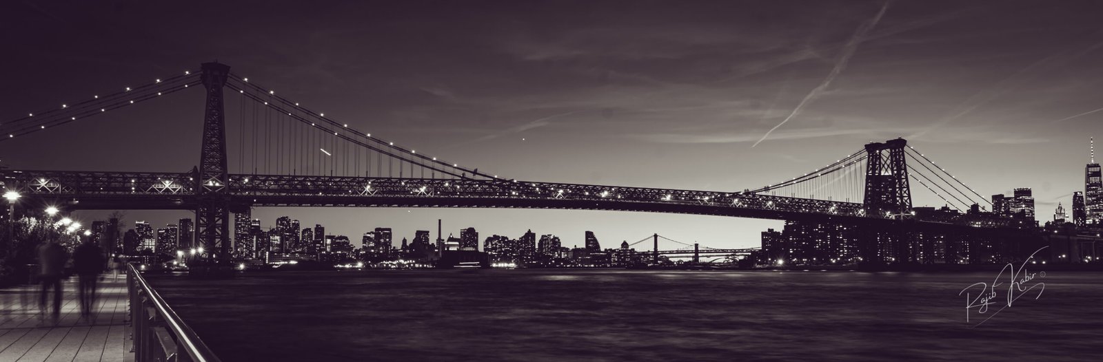 A breathtaking view of the Brooklyn Bridge with the New York City skyline illuminated at twilight.