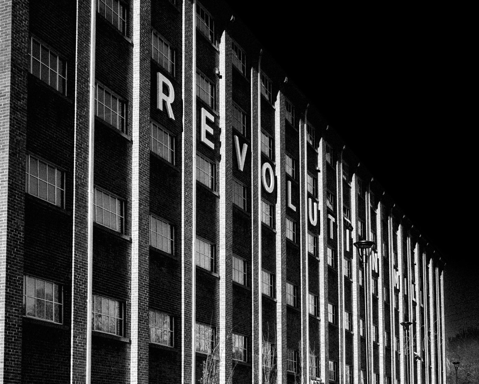 Black-and-white fine art photograph of Revolution Mill, capturing the industrial architecture and shadow play by Rajib Kabir Photography